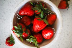 Fresh strawberries in a white collander.