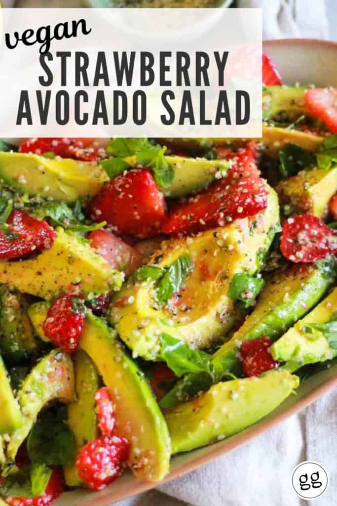 Avocado and berry salad on platter with text that reads, "Vegan Strawberry Avocado Salad."