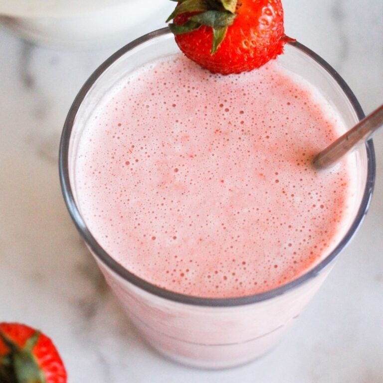 Vegan strawberry milkshake garnished with a fresh strawberry.