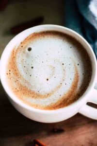 frothy latte in white mug