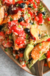 Closeup image of quinoa fruit salad with avocado and peach.