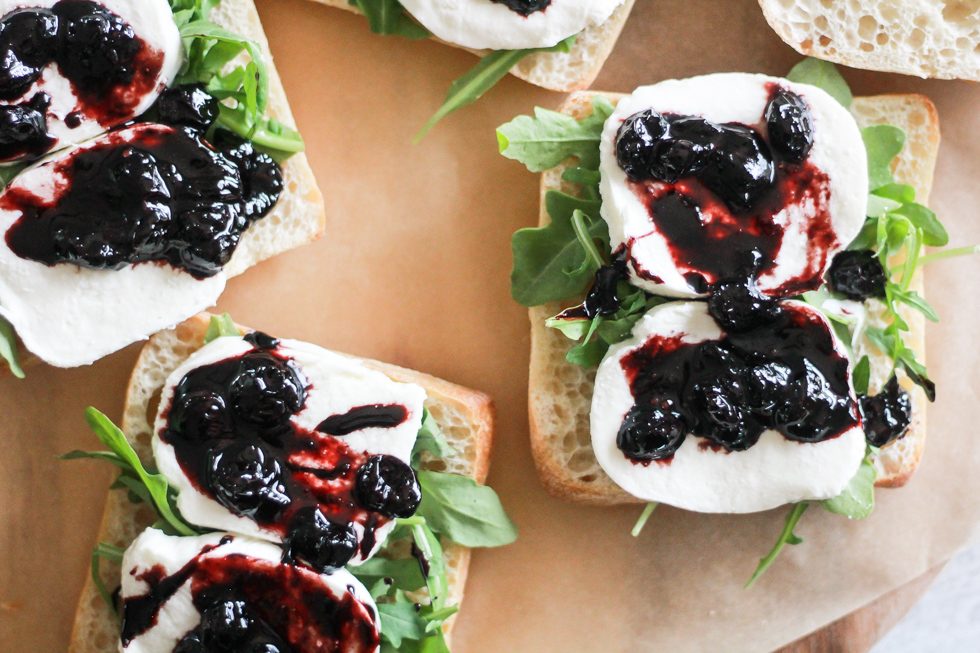 Open faced sandwiches with mozzarella and blueberry sauce.