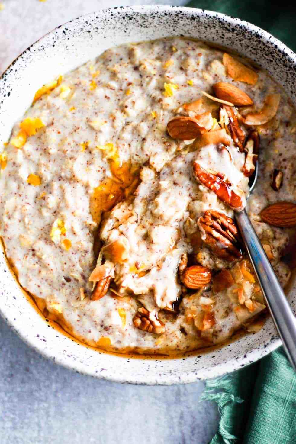 Oatmeal with nuts and maple syrup in a white ceramic bowl