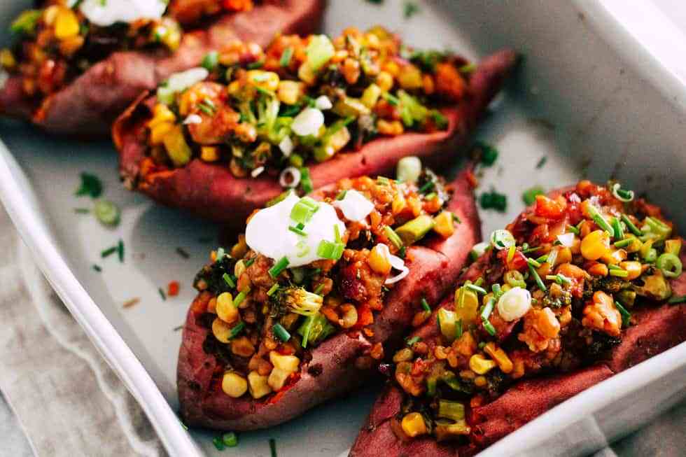 horizontal image of loaded sweet potatoes in grey casserole dish