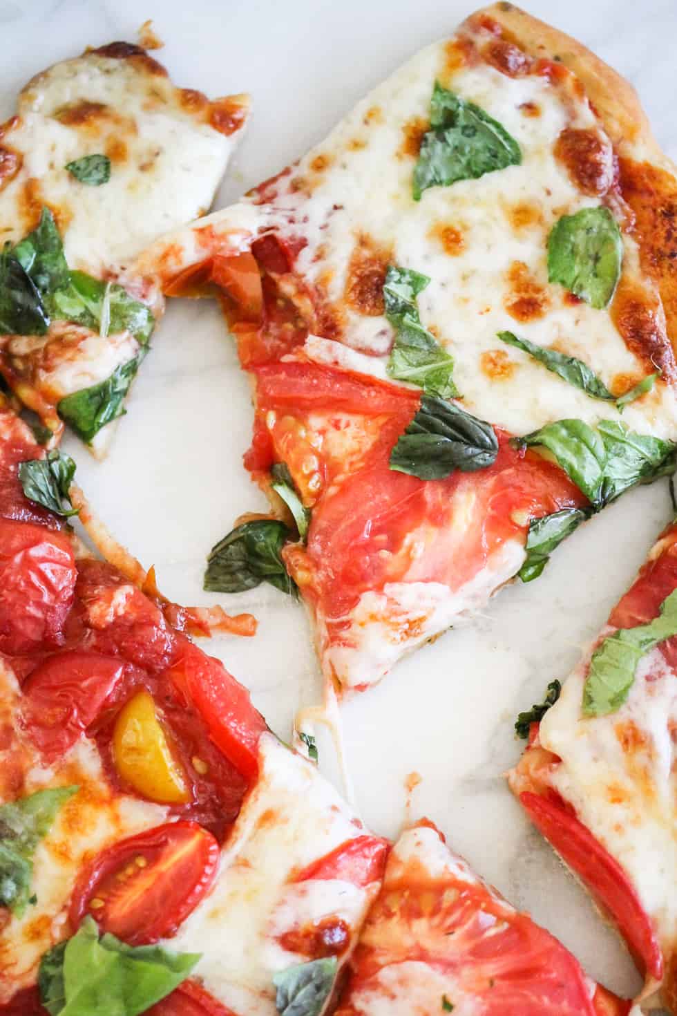 Closeup image of sliced Caprese Pizza on marble background.