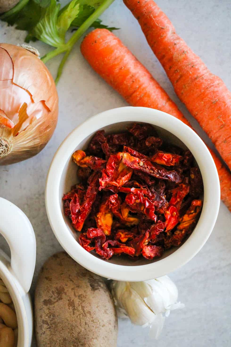 Bowl of sun-dried tomatoes with carrots, onion, and potato