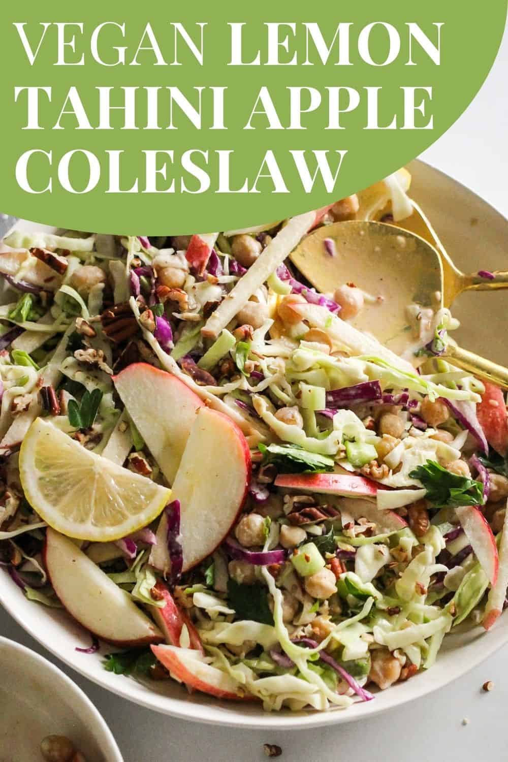 Cabbage slaw in white serving dish with green and white text that reads, "Vegan Lemon Tahini Apple Coleslaw."