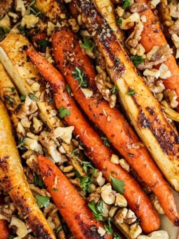 Vegetarian roasted carrots and parsnips with walnuts served for Thanksgiving or Christmas.