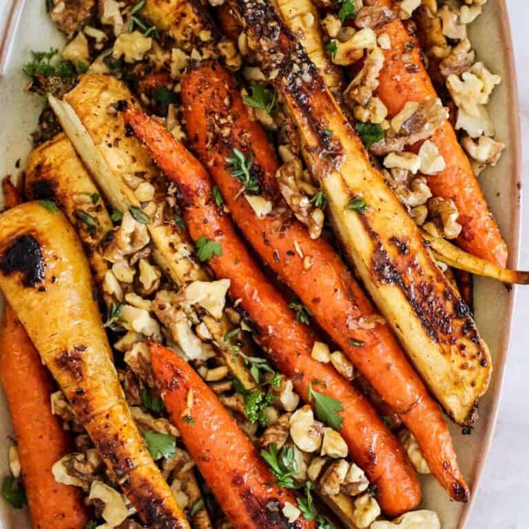 Vegetarian roasted carrots and parsnips with walnuts served for Thanksgiving or Christmas.