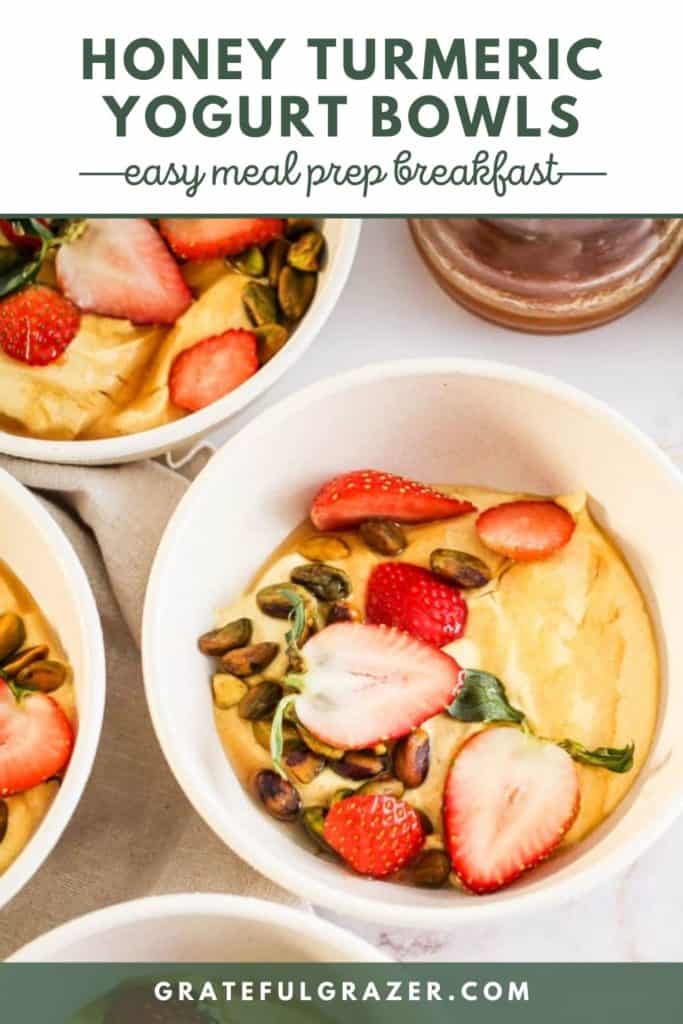 Turmeric yogurt bowls topped with strawberries and pistachios with green text reading, "Honey Turmeric Yogurt Bowls: Easy meal Prep Breakfast; GratefulGrazer.com."