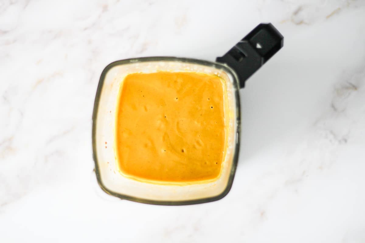 Overhead image of yellow curry sauce in a blender.