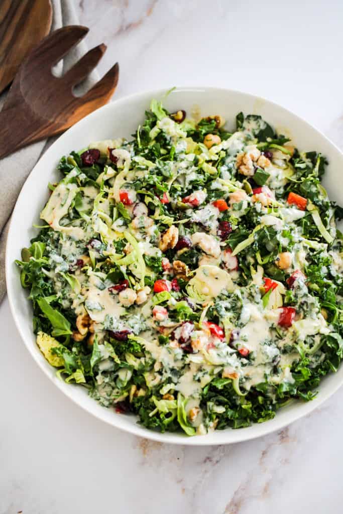 Meal Prep Salad in a large white bowl drizzled with creamy tahini dressing.