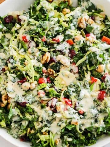 A hearty meal prep salad with kale, chickpeas, walnuts, and tahini dressing.