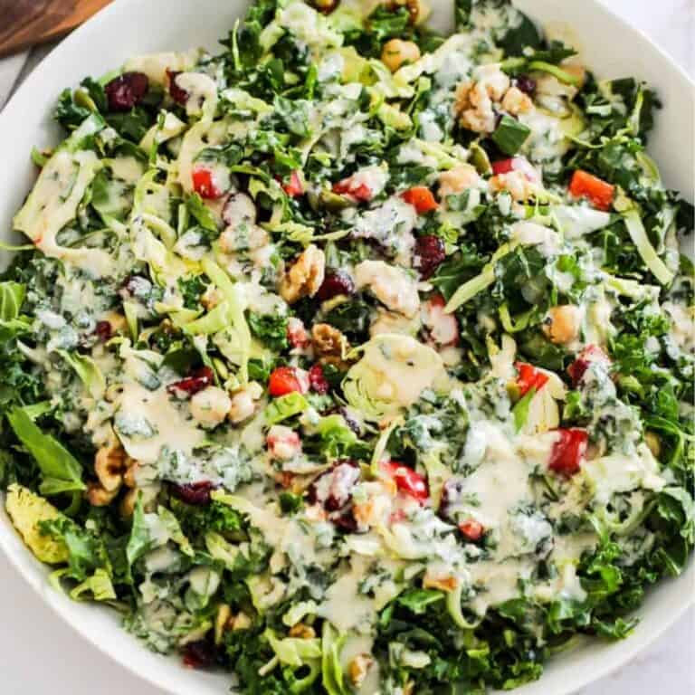 A hearty meal prep salad with kale, chickpeas, walnuts, and tahini dressing.