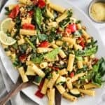 Platter of vegan pasta primavera with veggies and lemon cream sauce.