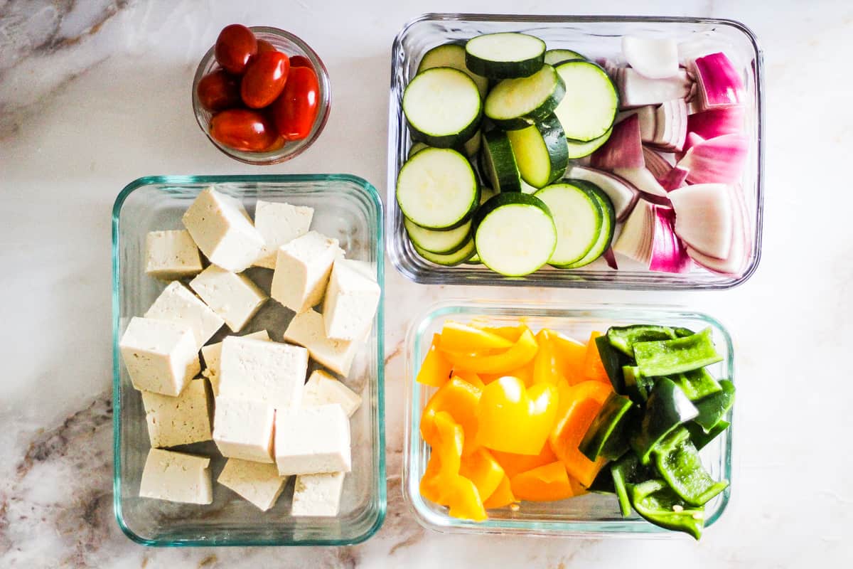 Tofu and vegetables in glass meal prep containers.