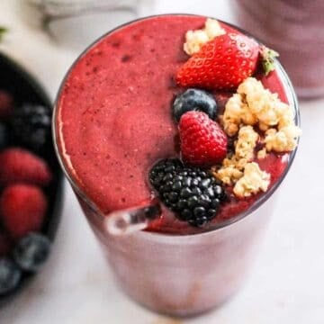 Coconut water smoothie with berries topped with fresh berries and granola.