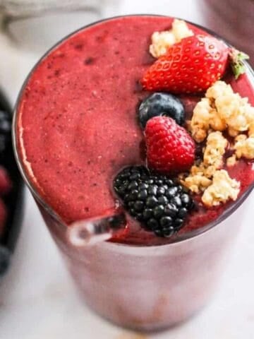 Coconut water smoothie with berries topped with fresh berries and granola.