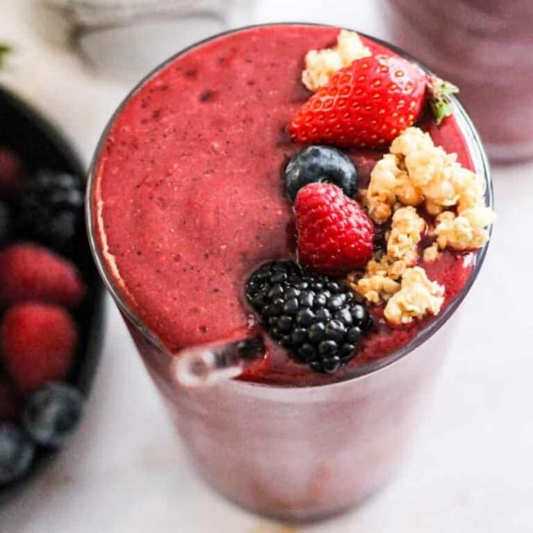 Coconut water smoothie with berries topped with fresh berries and granola.