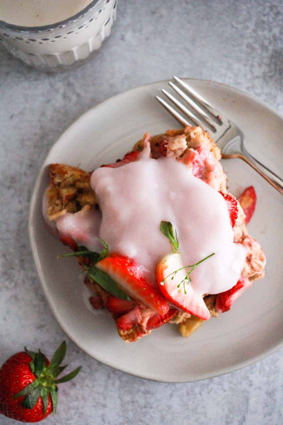 Strawberry Banana Baked Oatmeal Vegetarian Freezer Meal topped with strawberries and yogurt on a white plate.