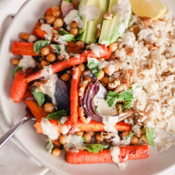 Vegan Rice Bowls with roasted carrots, chickpeas, avocado, and tahini sauce.