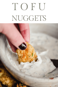 Hand dipping a tofu nugget into yogurt ranch dip. Text reads, "Tofu Nuggets."