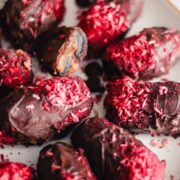 Chocolate Covered Dates with Peanut Butter and topped with raspberry coconut shreds.