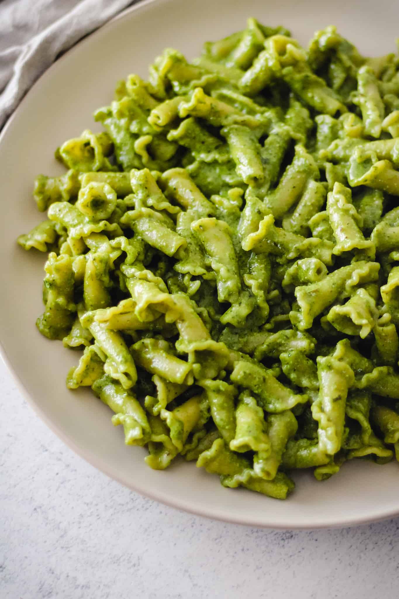 Closeup of creamy pesto pasta.