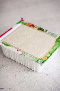 Tofu in the carton with the lid off.