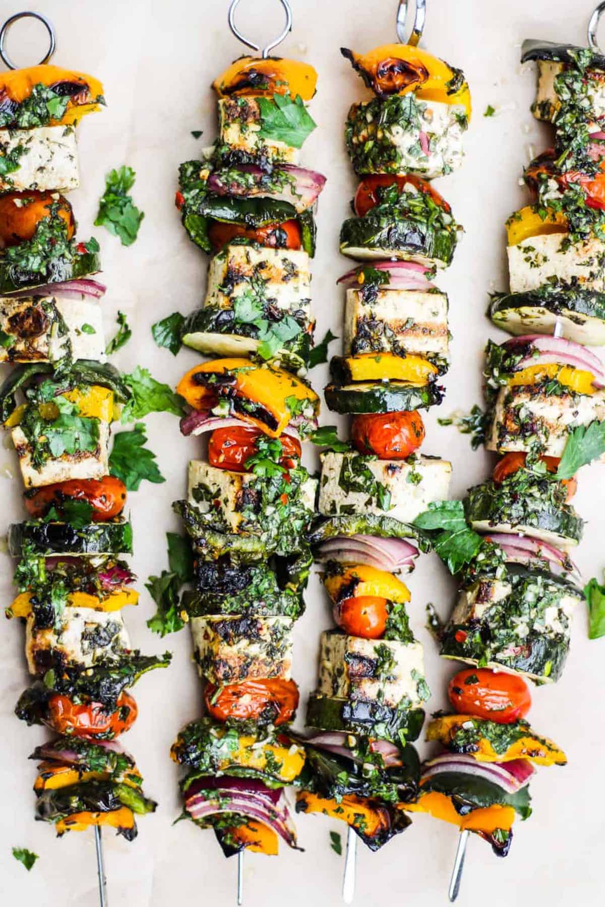 Tofu and vegetable skewers with chimichurri sauce.