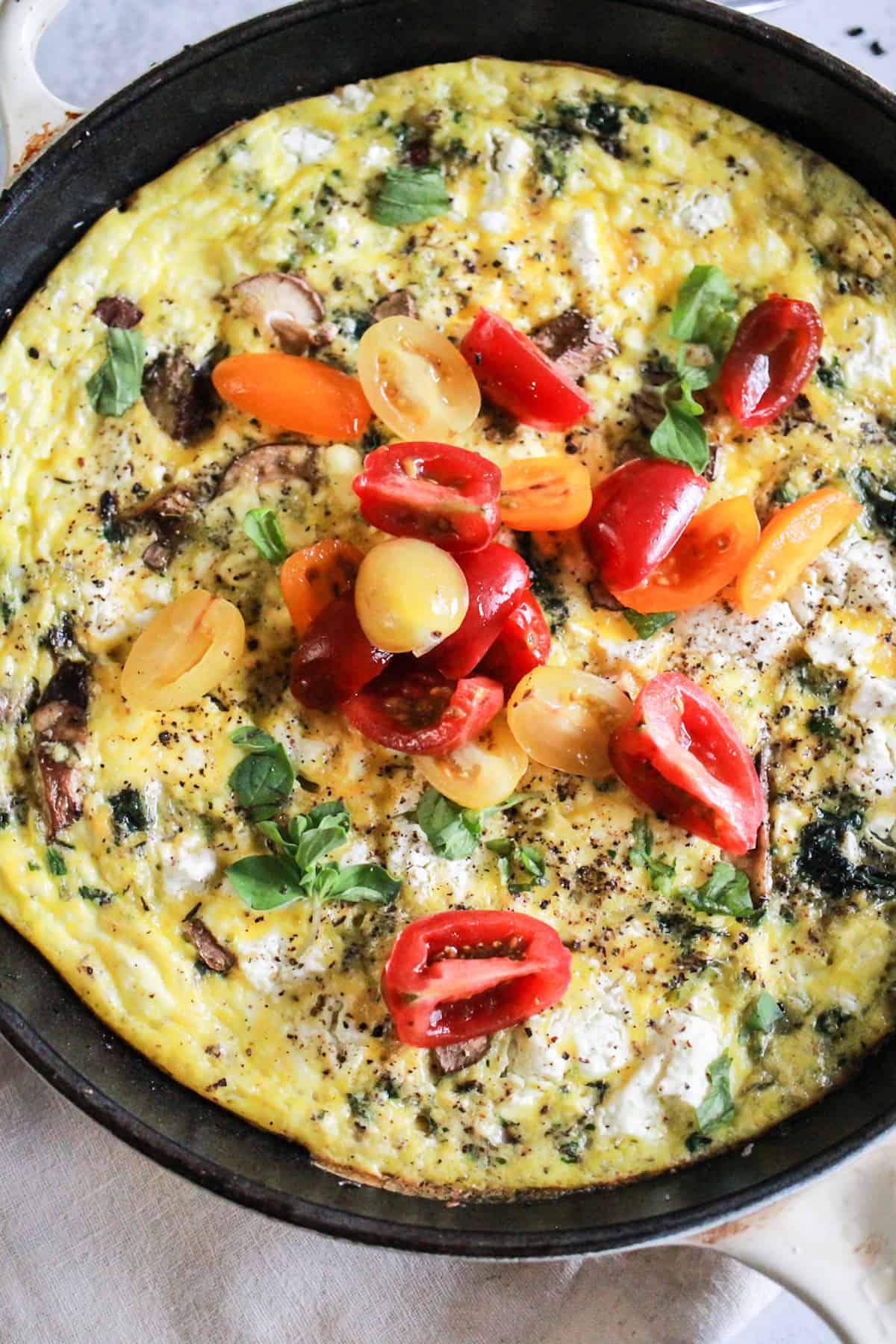 Vegetarian frittata in a white cast iron skillet.