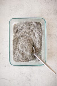 Chia seed pudding in a glass container with a spoon.