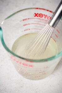 Pickle brine in a liquid measuring cup.