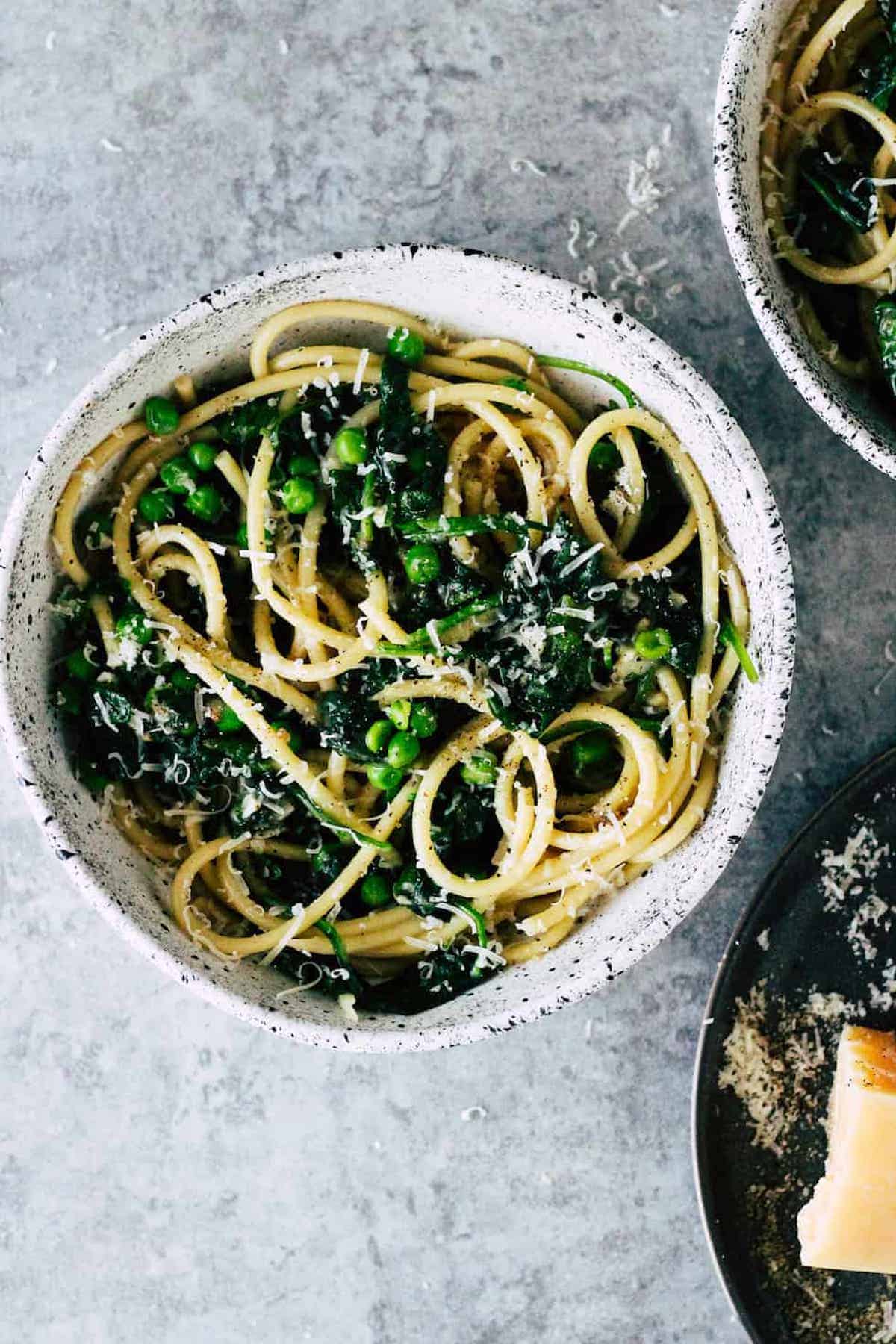 Cacio e pepe pasta with spinach and peas.