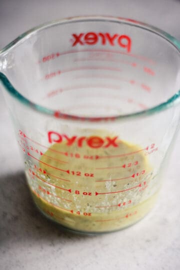 Making Greek salad dressing in a liquid measuring cup.