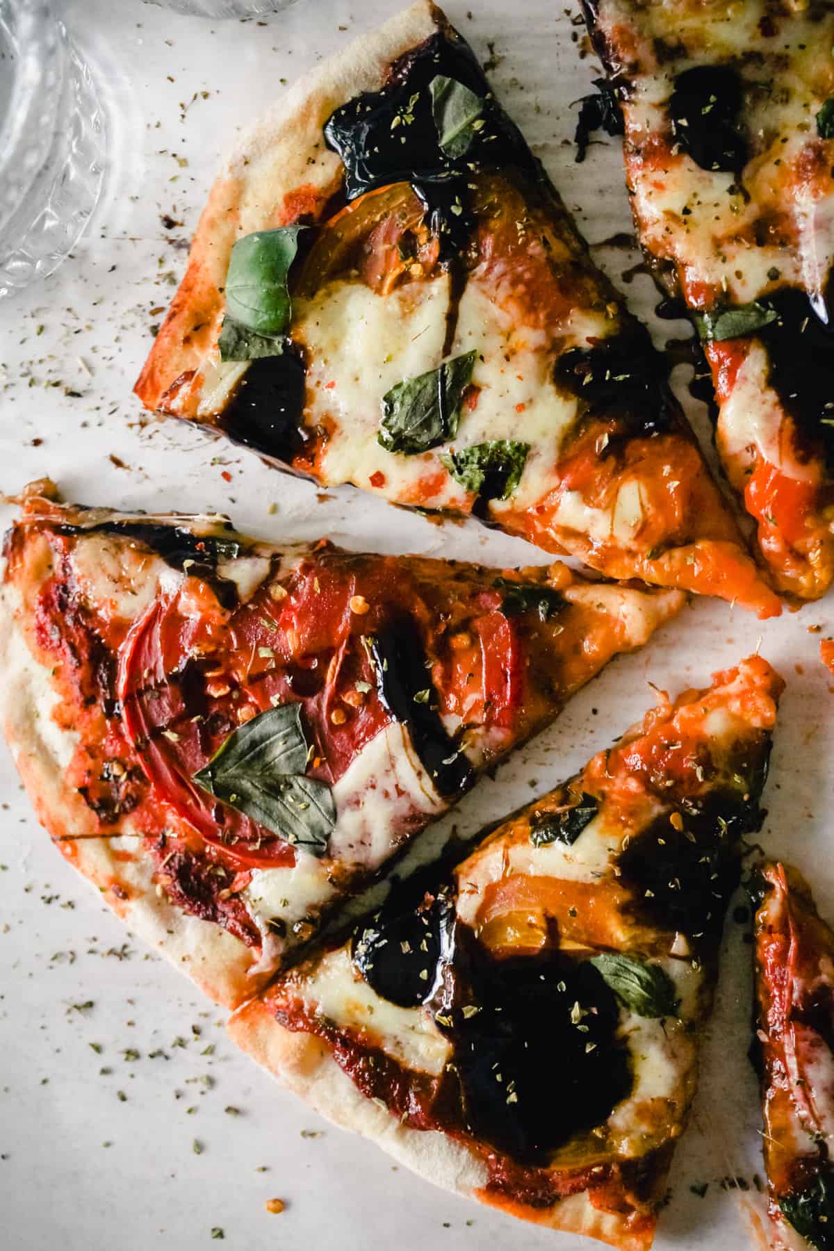 Caprese pizza slices with balsamic glaze.