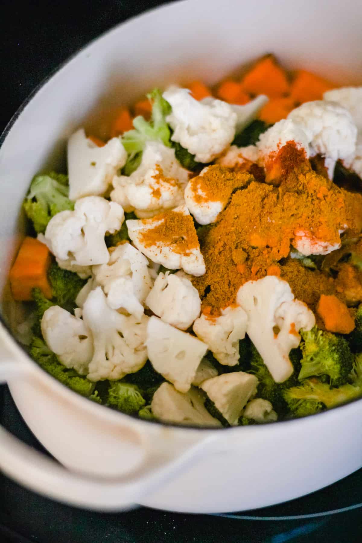 Add dried vegetables and spices to the Dutch oven to make pumpkin curry.