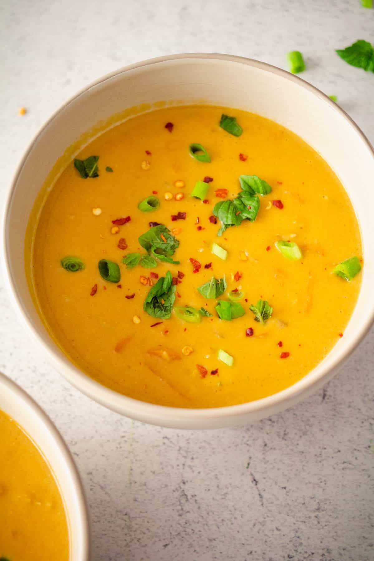 Creamy carrot and lentil soup in a white bowl.