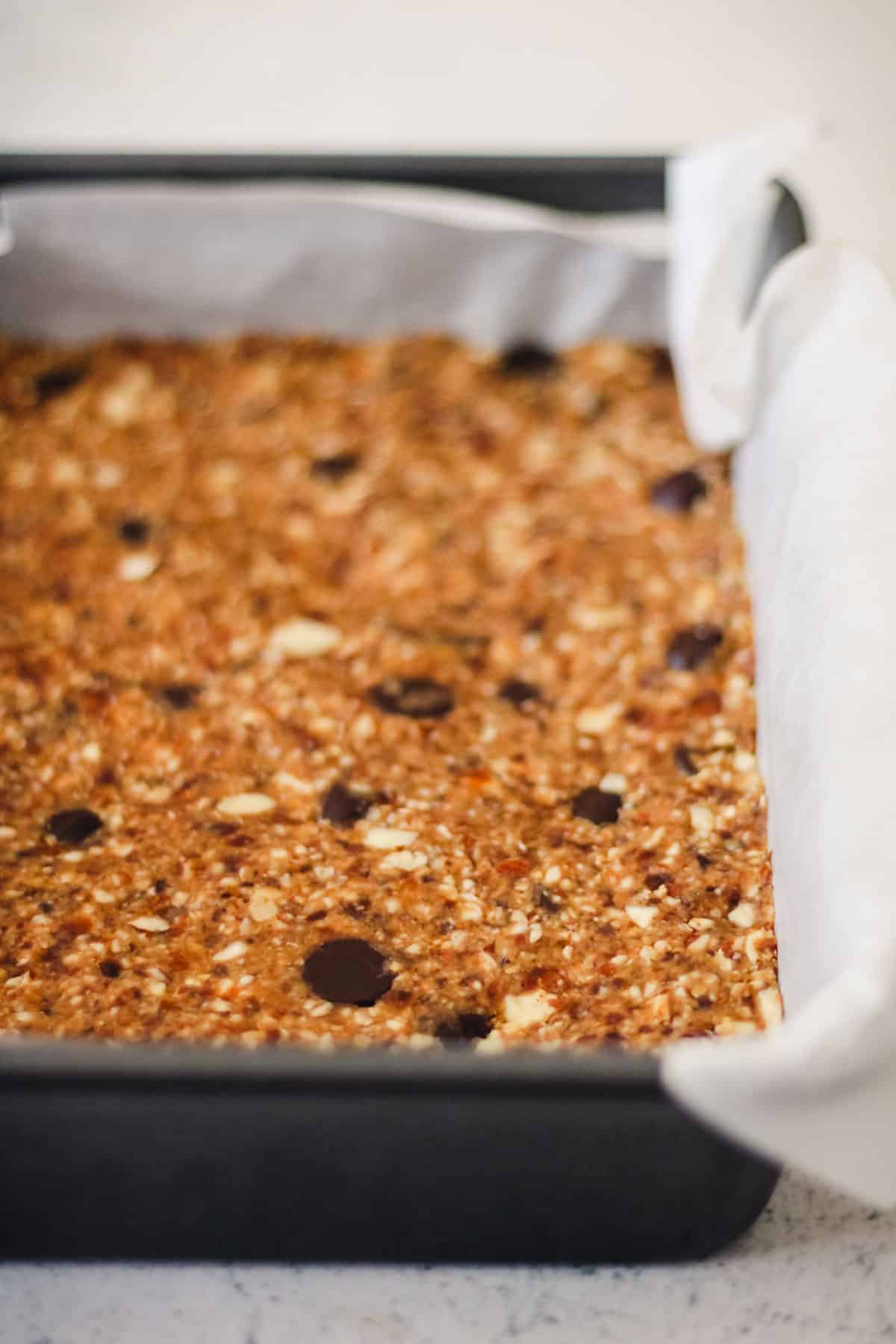Homemade no-bake energy bars squeezed into a baking dish.