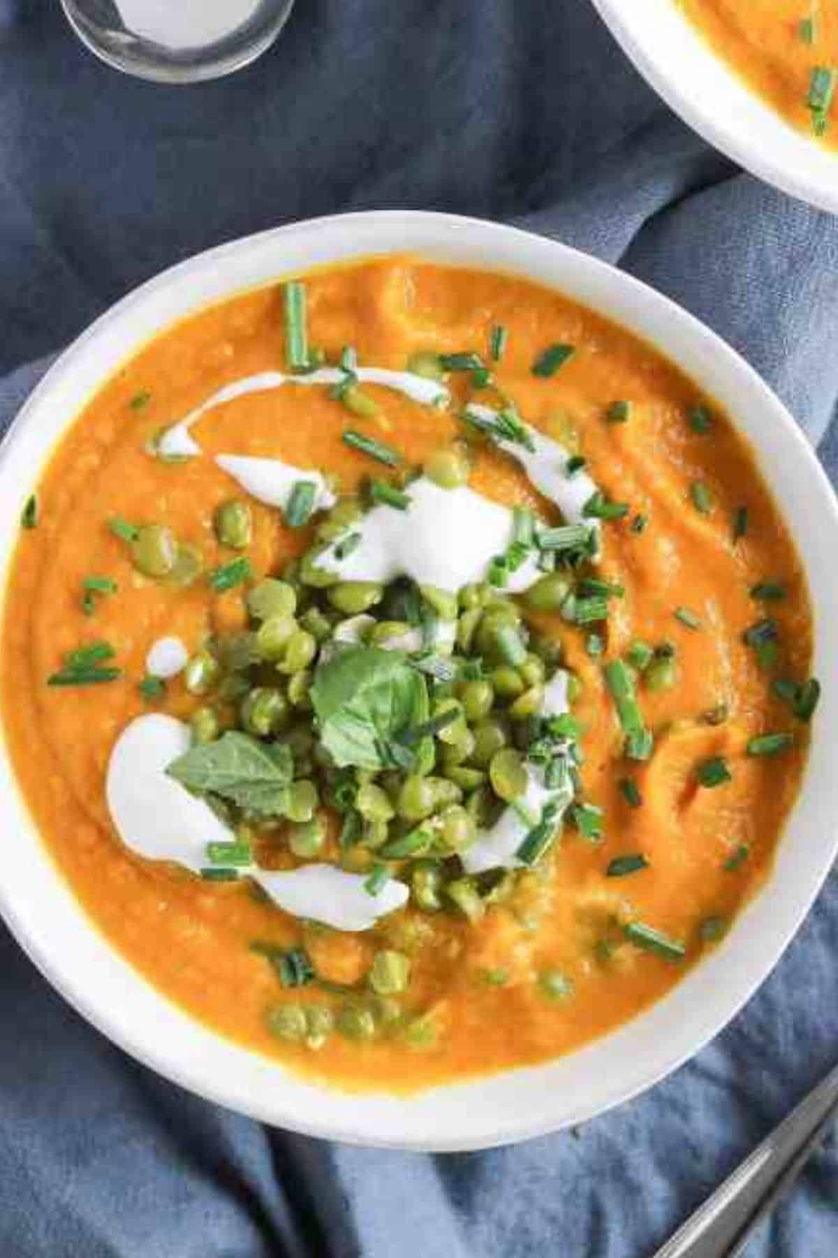 Creamy Carrot Ginger Sweet Potato Soup topped with green split peas and dairy-free yogurt.