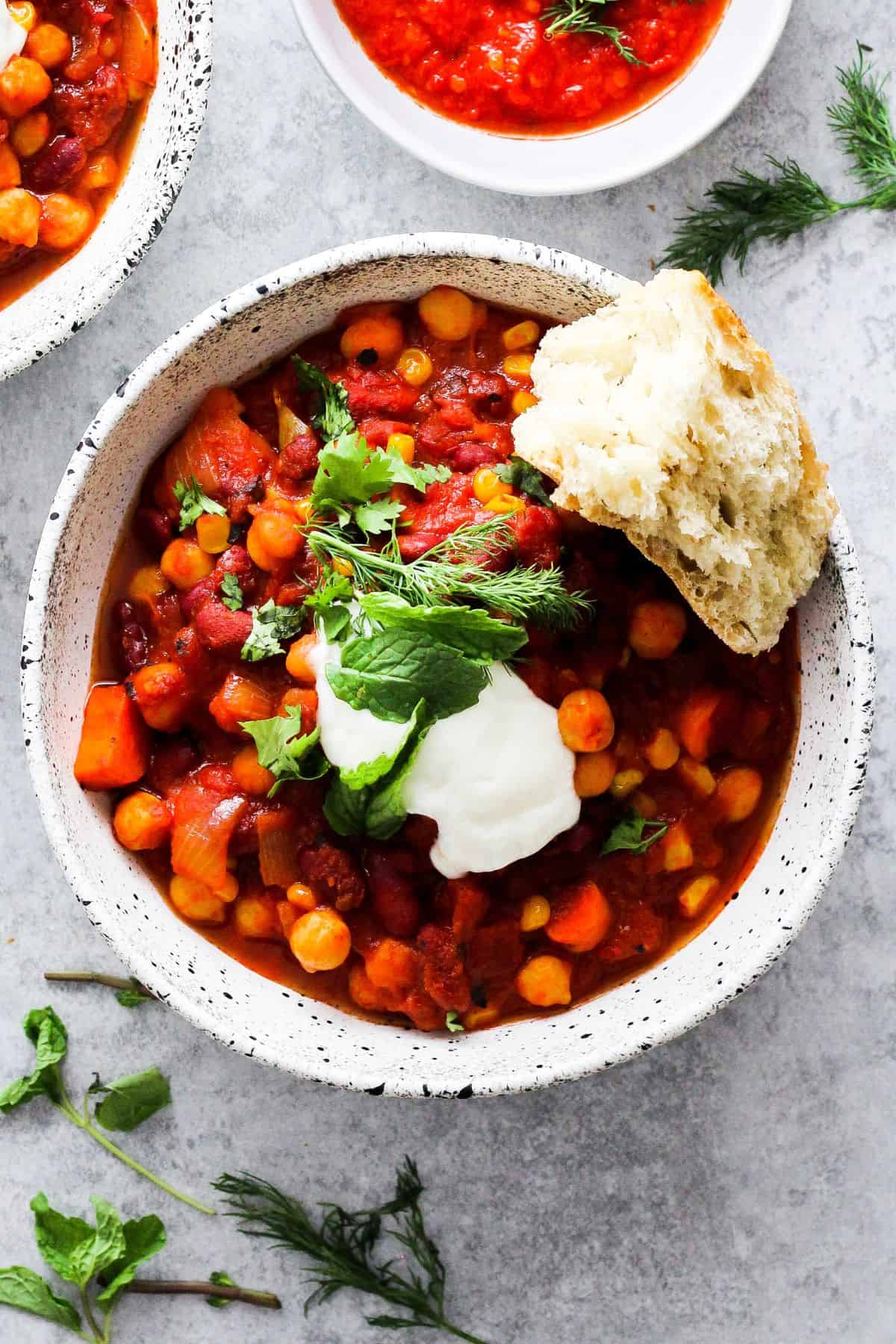 Chickpea chili with harissa paste served with a piece of bread.
