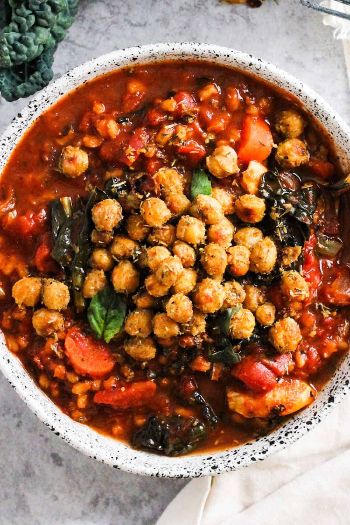 Vegan Tomato Barley Soup with vegetables topped with roasted chickpeas.