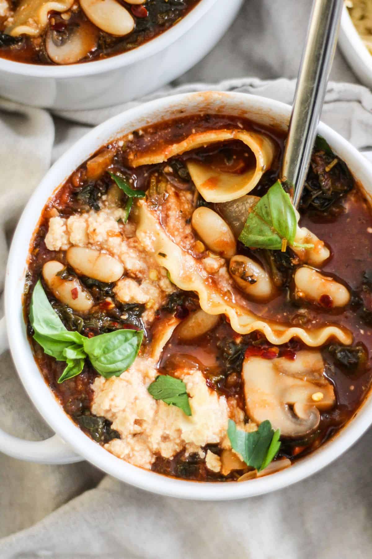 Vegan Lasagna Soup with white beans, mushrooms, and plant-based ricotta cheese.