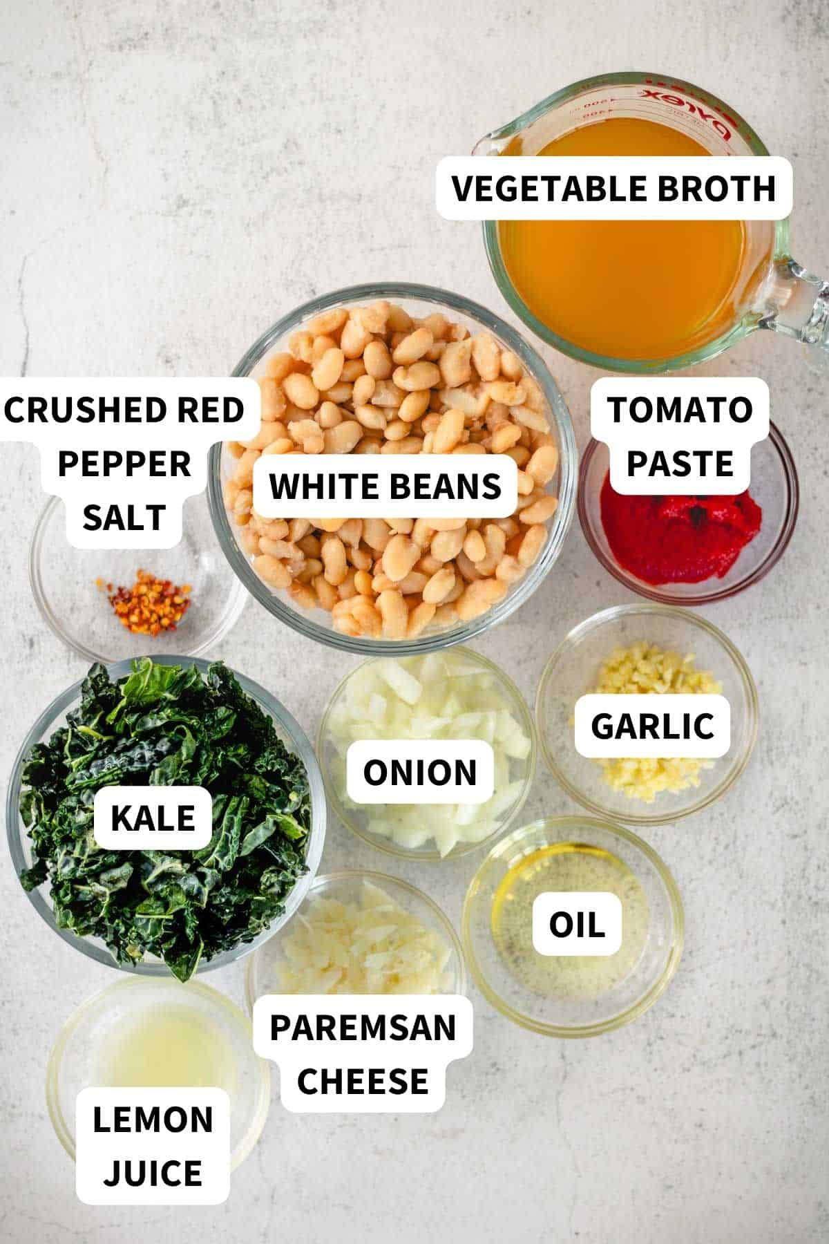 Ingredients with text labels to make white beans and greens with kale and tomato sauce.