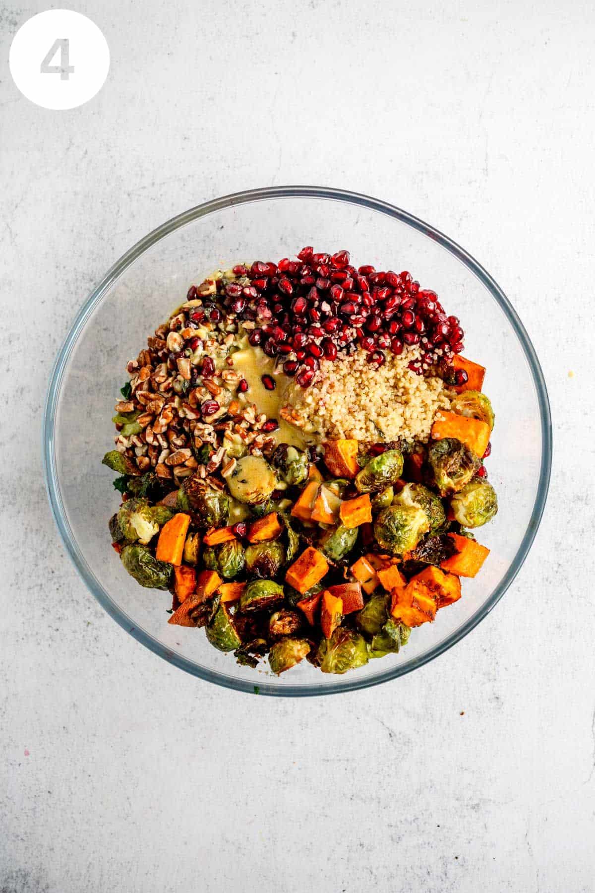 Quinoa salad with roasted vegetables unmixed in a glass bowl.