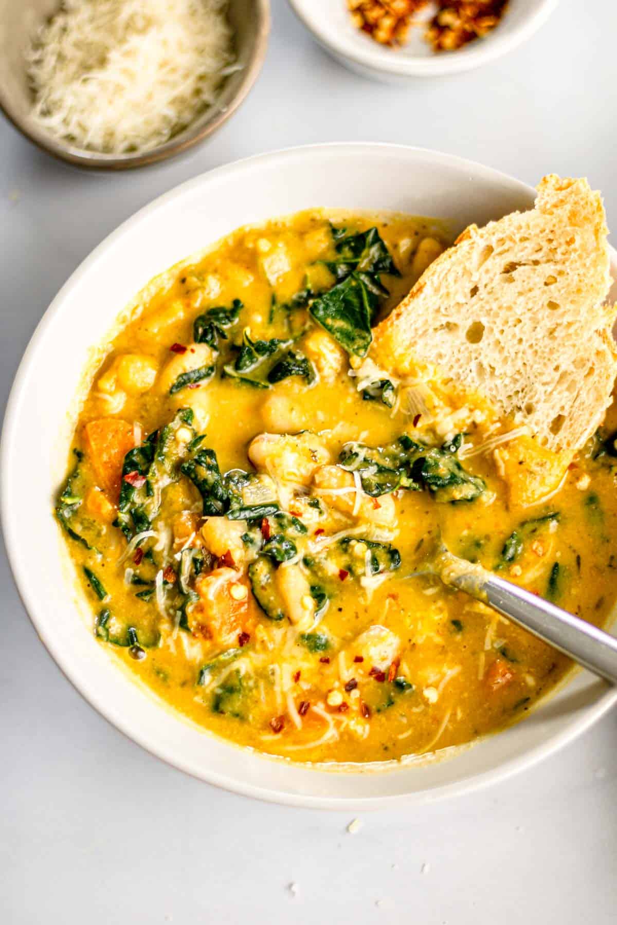 Creamy Tuscan White Bean Soup with kale served with fresh bread.