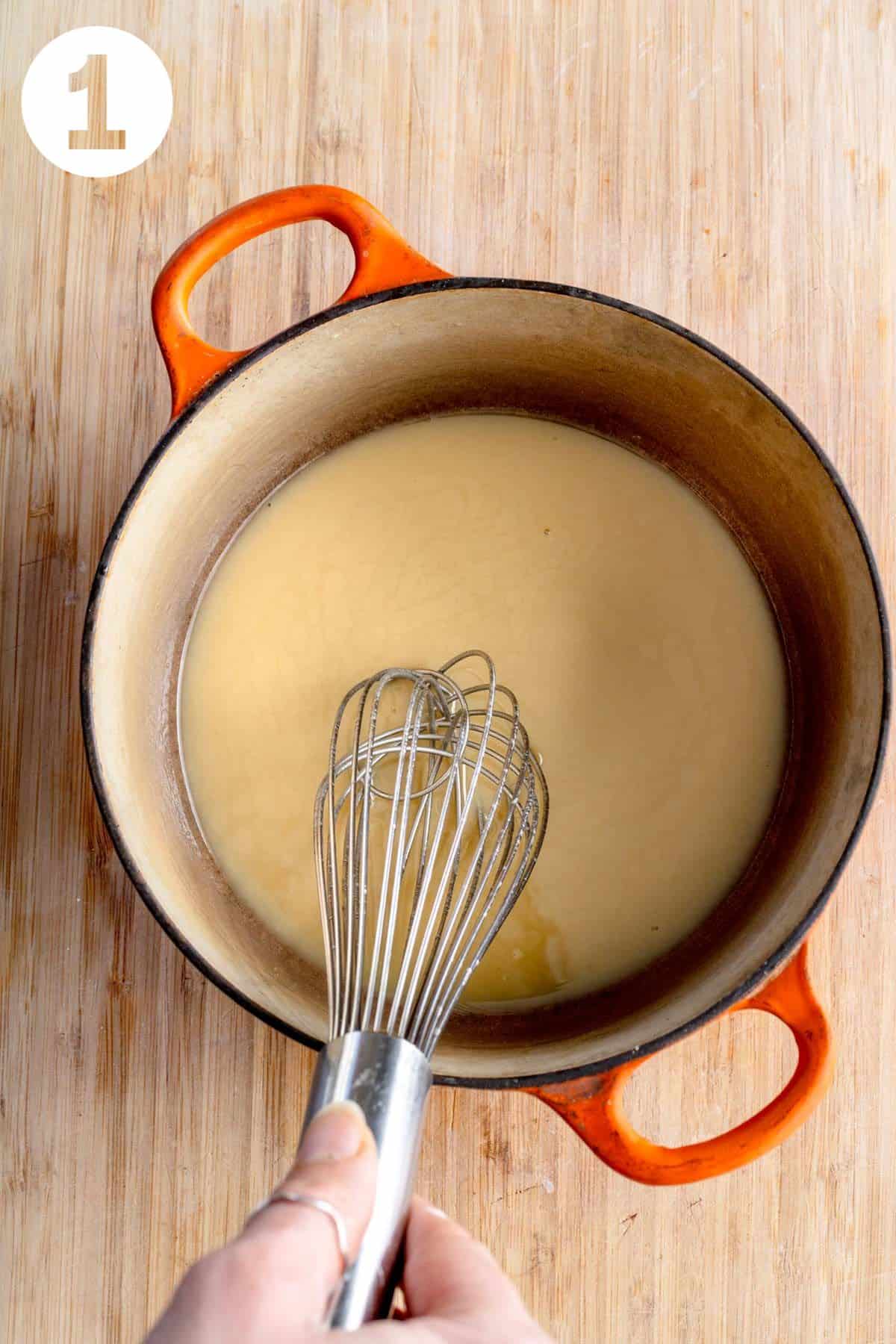 Whisking oil and flour in a small pot.