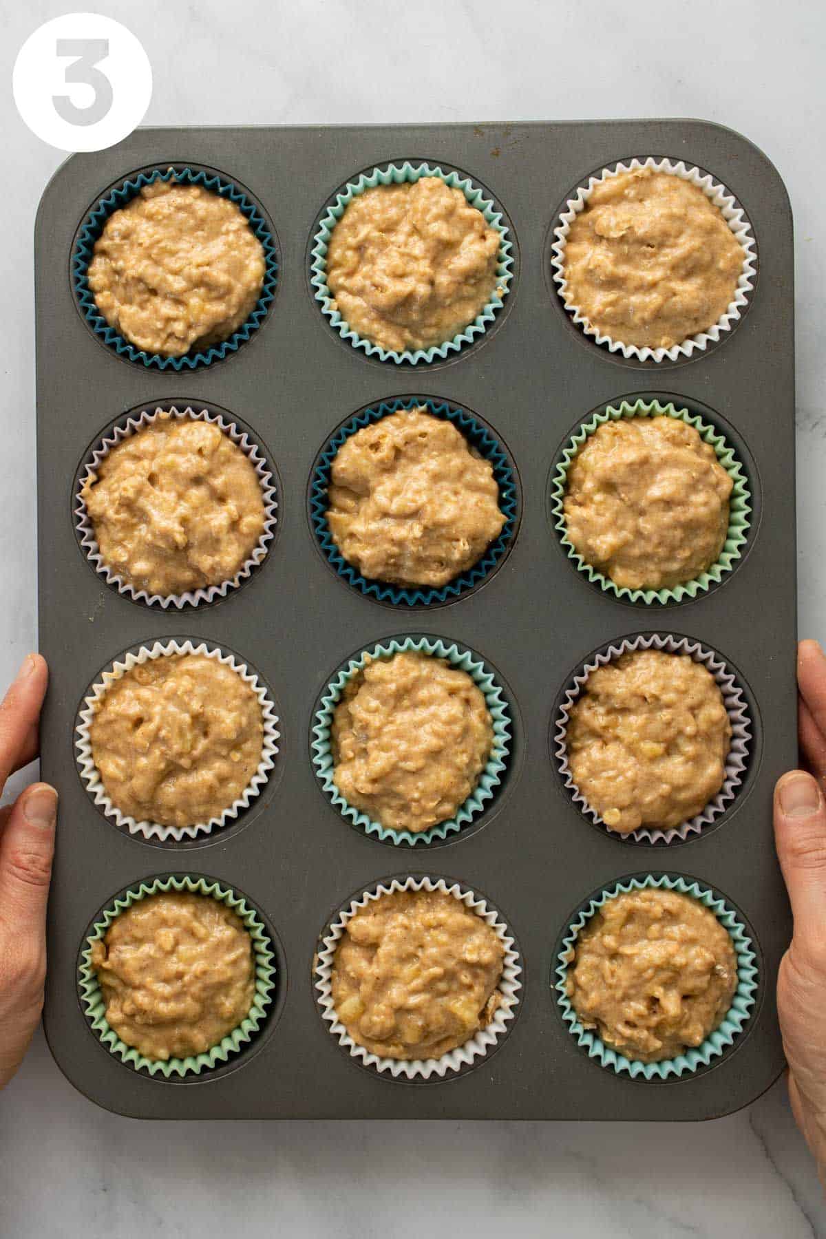 Holding a muffin pan with unbaked batter. Labeled with a "3" in upper left corner.