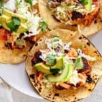 Plated fish tacos with salmon, slaw, and avocado.