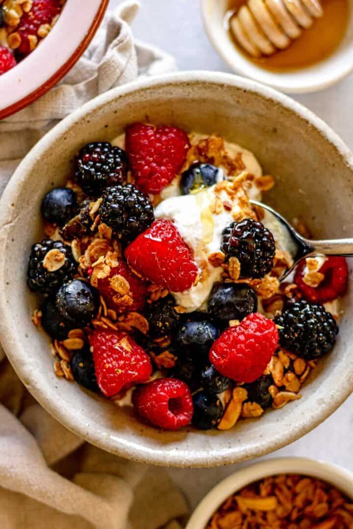 Greek yogurt bowl topped with fresh berries, granola, and honey